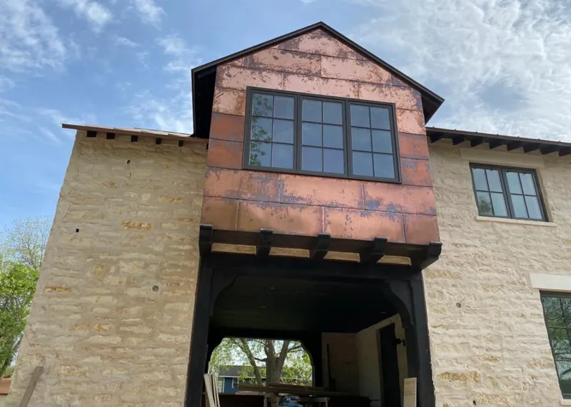 Copper metal panel facade on a stone building for Roof Repair in Northport