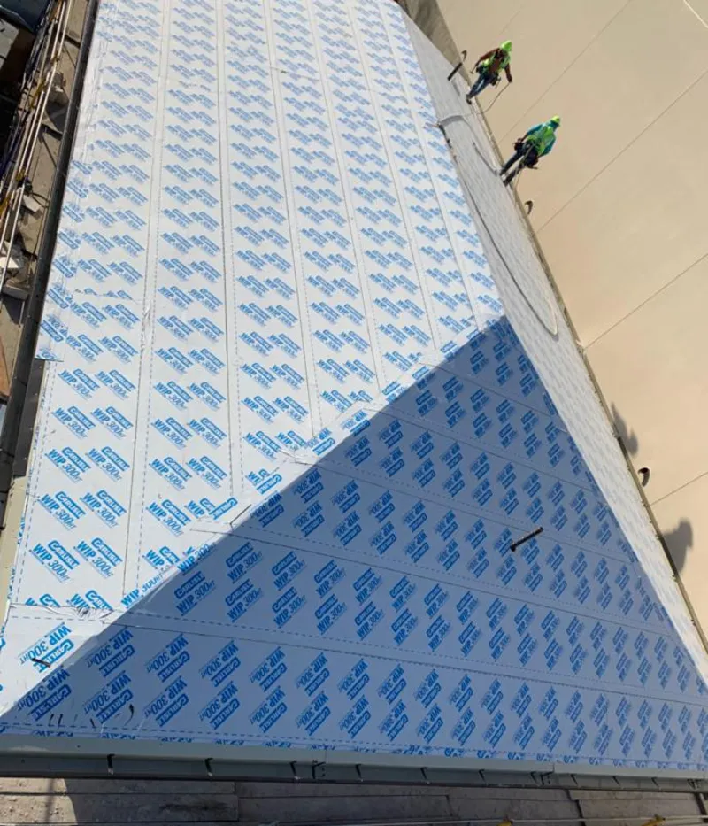 Professional roofers installing underlayment on a metal roof in Northport